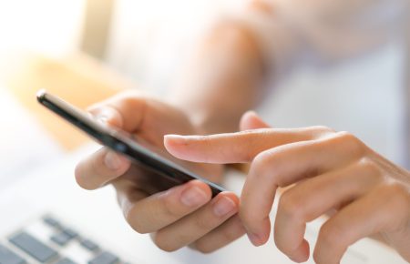 Business woman hand with Financial charts and mobile phone over